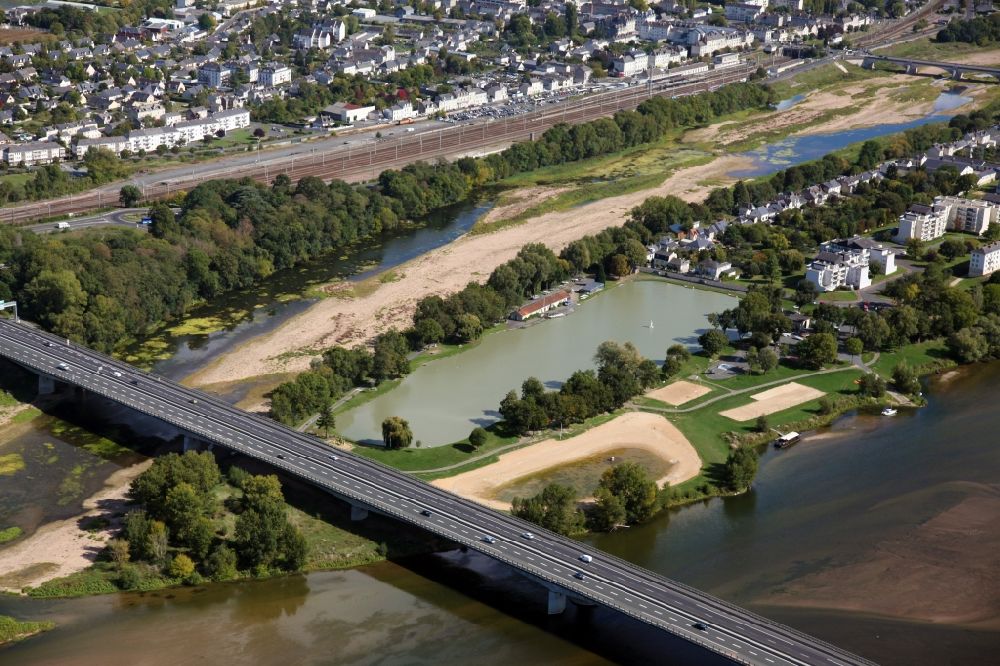 Saumur from the bird's eye view: River - bridge construction over the Loire in Saumur in Pays de la Loire, France. Behind the Bridge the Pond Millocheau with rowing boats and sailing boats