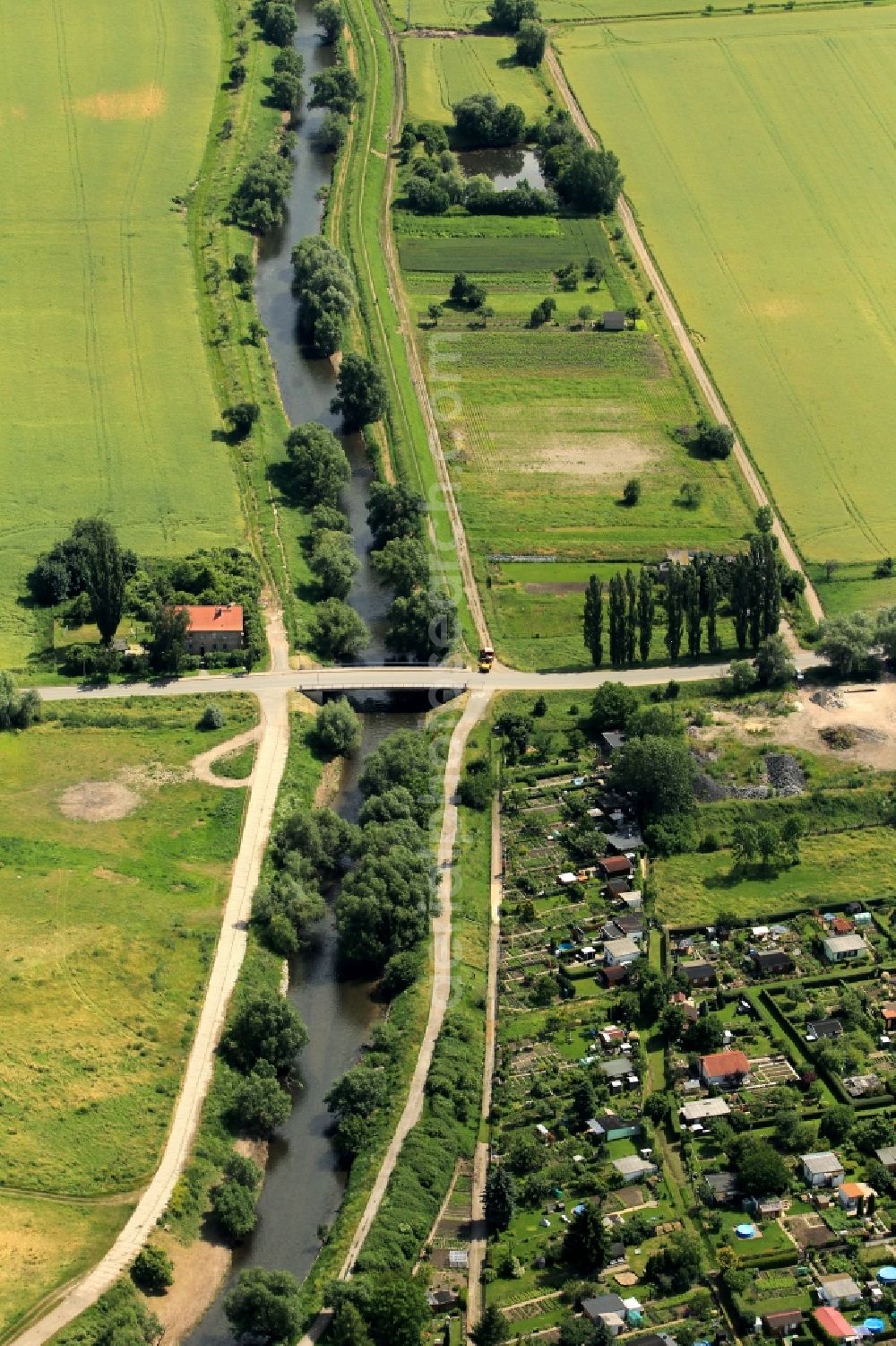 Aerial image Walschleben - The river Gera flows at Walschleben in Thuringia past. In the environment of the river is the garden colony Gera Aue. The Bahnhofstrasse road crosses the bridge over the river