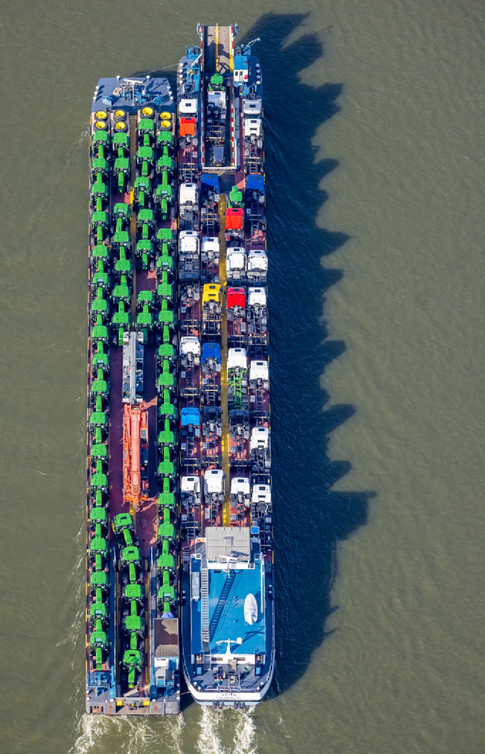 Aerial photograph Duisburg - Cargo ship loaded with tractors and trucks in inland waterways in driving on the waterway of the river of the Rhine river in the district Baerl in Duisburg at Ruhrgebiet in the state North Rhine-Westphalia, Germany