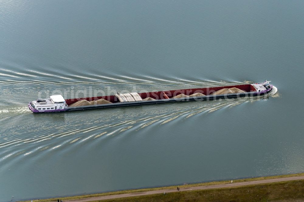 Daubensand from above - Cargo ships and bulk carriers on the inland shipping waterway of the river course of the Rhine river in Daubensand in Grand Est, France