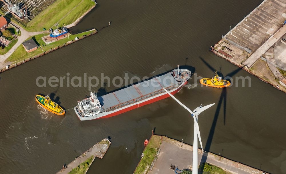 Aerial photograph Husum - Cargo ship and bulk freighter on the Husumer Au with tugboat help in the port of Husum in the state Schleswig-Holstein, Germany