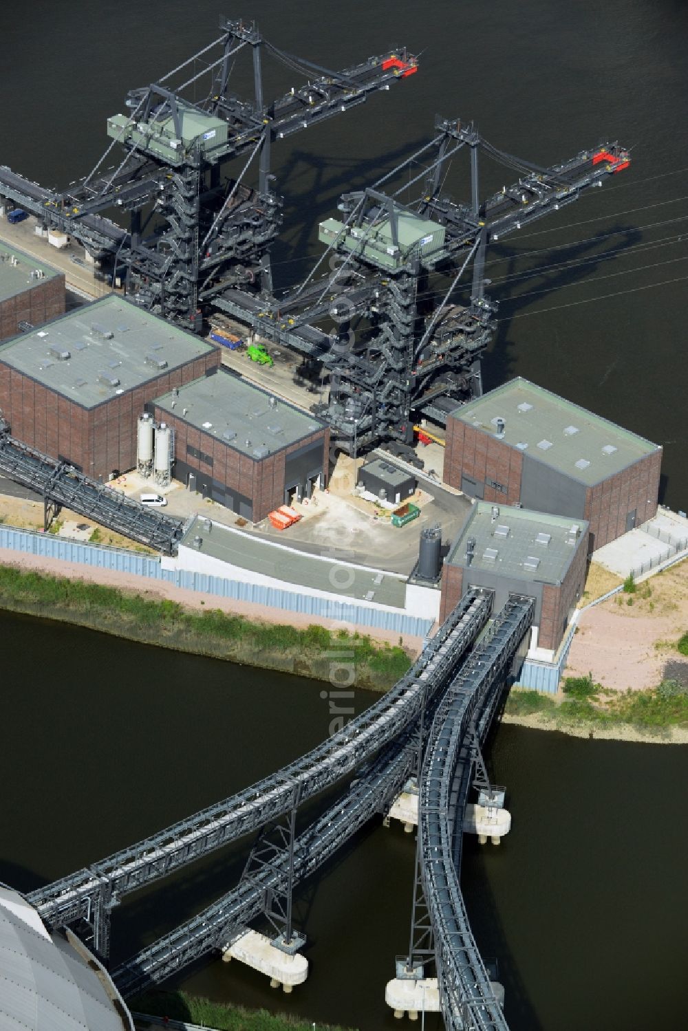 Hamburg from the bird's eye view: Conveyor bridges and harbor crane charges to the coal bunkers of coal-fired power station Moorburg on the banks of the Elbe in Hamburg