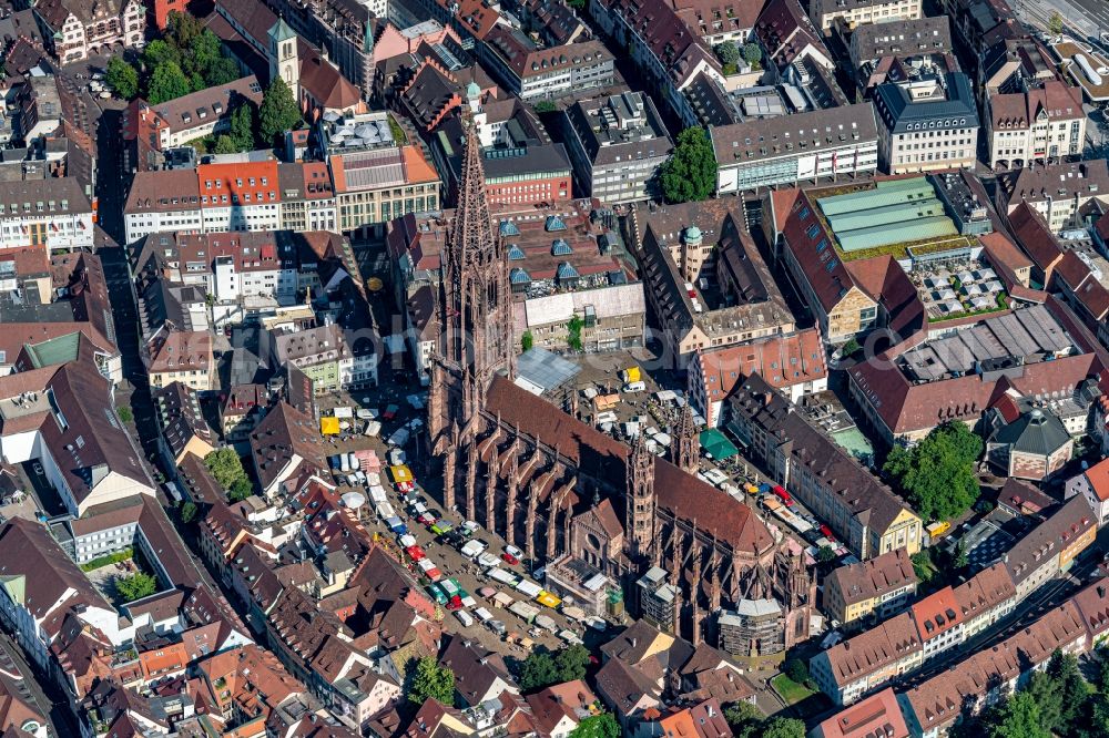 Freiburg im Breisgau from above - Church building Freiburger Muenster and market activities in the Old Town- center of downtown Freiburg im Breisgau in the state Baden-Wurttemberg, Germany