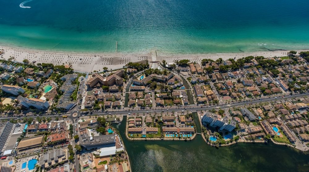 Aerial image Alcudia - Complex of the hotel buildings on the peninsula between the Mediterranean Sea and the lake Es Llac Gran on the Carrer de les Canyes along the Carretera d'Arta in Alcudia in Balearic island of Mallorca, Spain