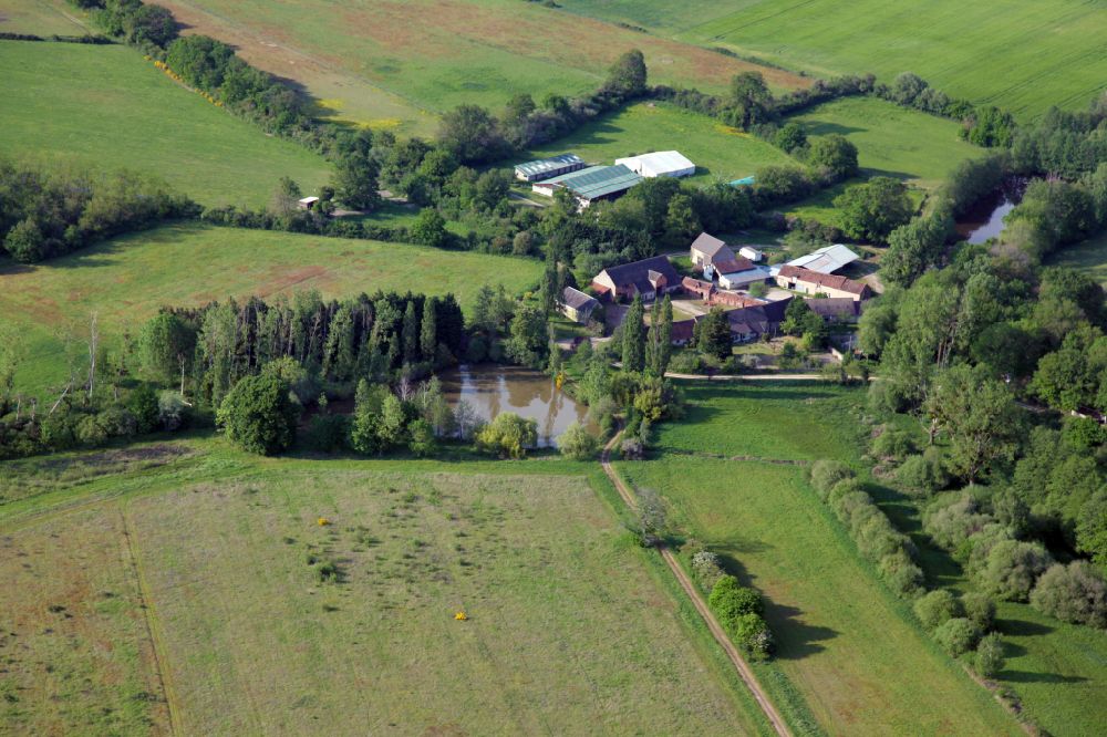 Aerial image Lion-en-Sullias - Homestead and farm outbuildings on the edge of agricultural fields at a pond in Lion-en-Sullias in Centre, France