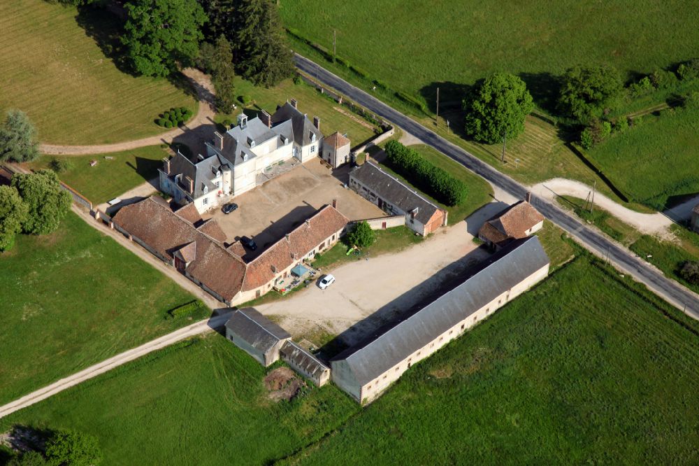 Saint-Florent from the bird's eye view: Homestead and farm outbuildings on the edge of agricultural fields with a small castle in Saint-Florent in Centre-Val de Loire, France