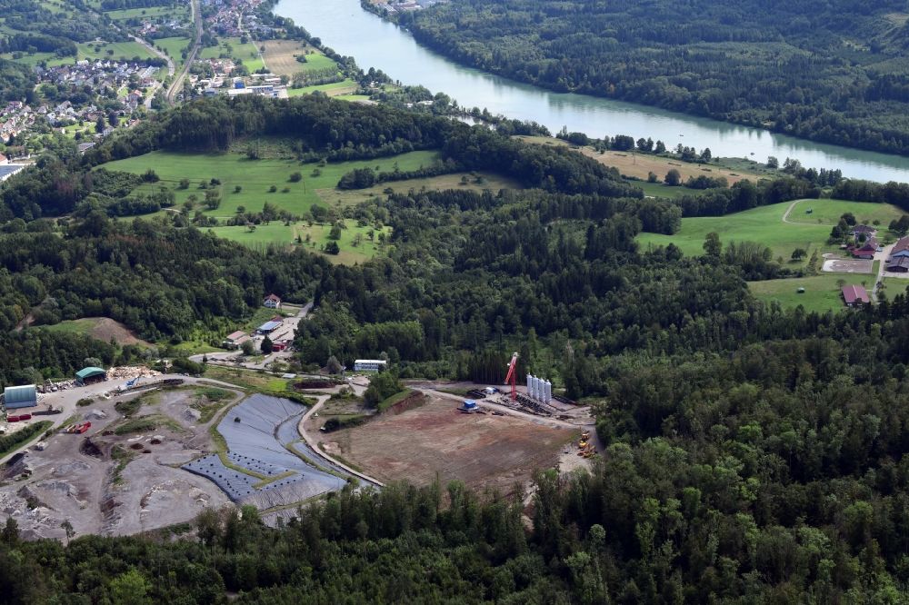 Schwörstadt from the bird's eye view: Site of heaped landfill Lachengraben with construction works and cleared area to expand the storage site in Wehr in the state Baden-Wurttemberg. Looking over the absorbtion towers of the TENP Trans Europa Naturgas Pipeline deodorization plant and river Rhine into Switzerland