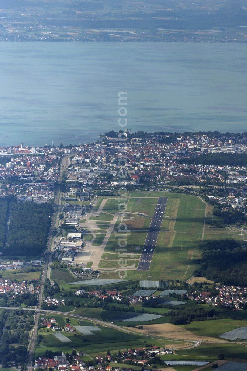Friedrichshafen from the bird's eye view: Runway with Hangars, taxiways, fair grounds, Dornier Museum and terminals on the grounds of the airport EDNY in Friedrichshafen in the state Baden-Wuerttemberg, Germany