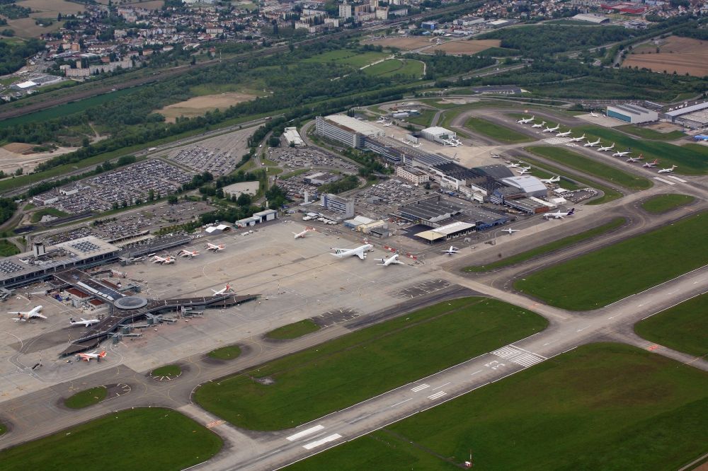 Aerial image Saint-Louis - Runway with Hangars, taxiways and terminals on the grounds of the airport Euroairport in Saint-Louis in Alsace-Champagne-Ardenne-Lorraine, France. Many airliners are parked on the runway RWY 26