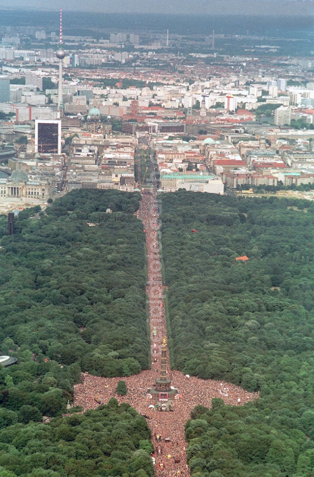 Berlin from the bird's eye view: Participants in the Love Parade music festival on the event concert area on the Great Star at the Victory Column and the Strasse des 17. Juni in the district Tiergarten in Berlin, Germany