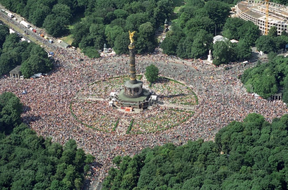 Berlin from the bird's eye view: Participants in the Love Parade music festival on the event concert area on the Great Star at the Victory Column and the Strasse des 17. Juni in the district Tiergarten in Berlin, Germany