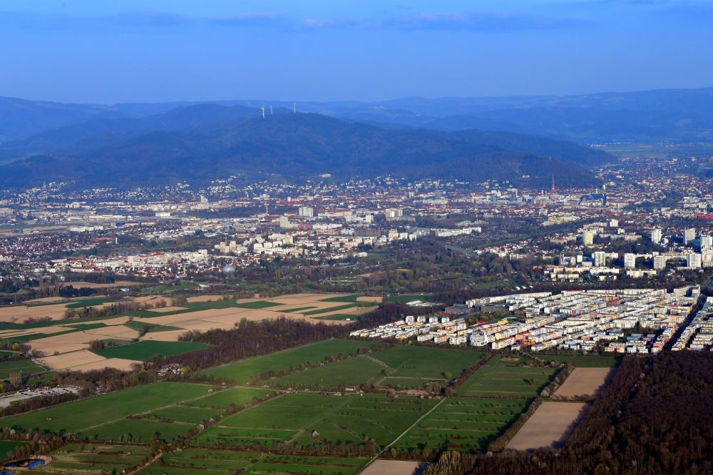 Aerial image Freiburg im Breisgau - City area with outside districts Rieselfeld und Dietenbach in Freiburg im Breisgau in the state Baden-Wurttemberg, Germany. Looking to the mountains of the Black Forest