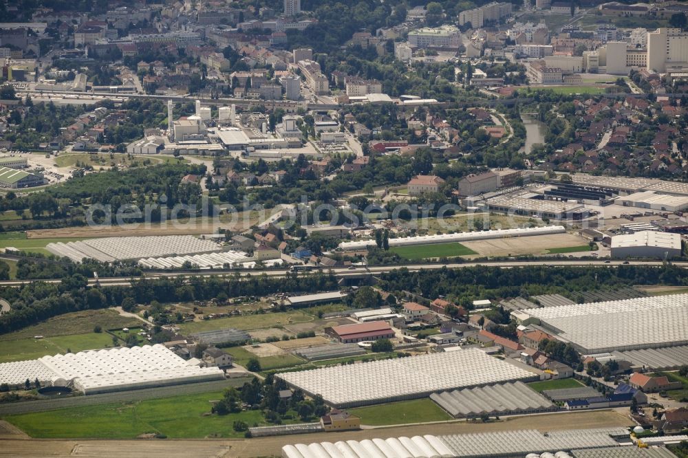 Schwechat from the bird's eye view: Industrial estate and company settlement along federal motorway A4 in Schwechat in Lower Austria, Austria. The area is located at the edge of the city of Vienna with the Kaiserebersdorf part of Vienna in the background