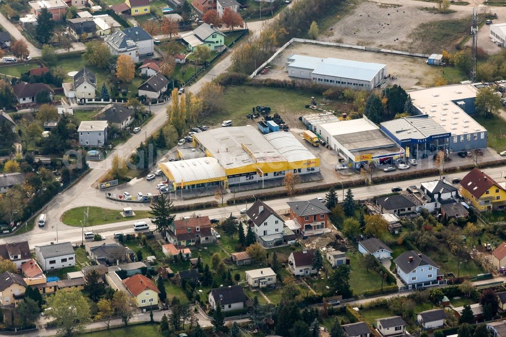 Strasshof an der Nordbahn from the bird's eye view: Industrial estate and company settlement on Hauptstrasse in Strasshof an der Nordbahn in Lower Austria, Austria. The area in the South of a residential area with houses and gardens includes the company grounds of Reifen John GmbH & Co KG. and Flix Karniesen und Sonnenschutz GmbH & Co KG