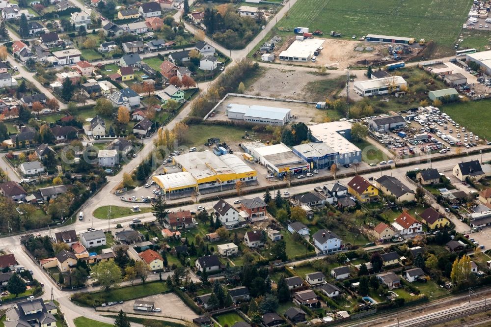 Aerial image Strasshof an der Nordbahn - Industrial estate and company settlement on Hauptstrasse in Strasshof an der Nordbahn in Lower Austria, Austria. The area in the South of a residential area with houses and gardens includes the company grounds of Reifen John GmbH & Co KG. and Flix Karniesen und Sonnenschutz GmbH & Co KG
