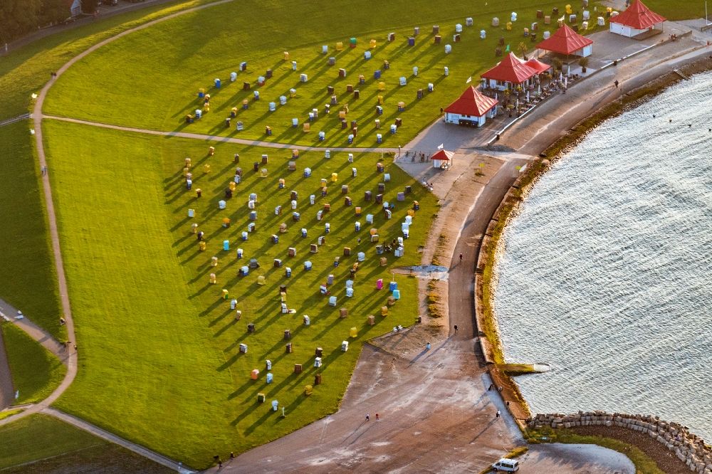 Aerial photograph Cuxhaven - The Grimmershoernbucht with the dike system Doeser Sea dike with beach chairs in the evening sun in Cuxhaven Doese in the state of Lower Saxony