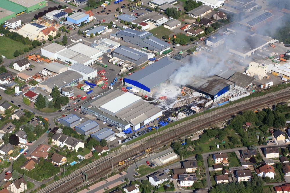 Aerial photograph Efringen-Kirchen - Major fire in a warehouse of a recycling company in Efringen-Kirchen in the state of Baden-Wuerttemberg. The Great Fire in a residential area generated tons of hazardous waste