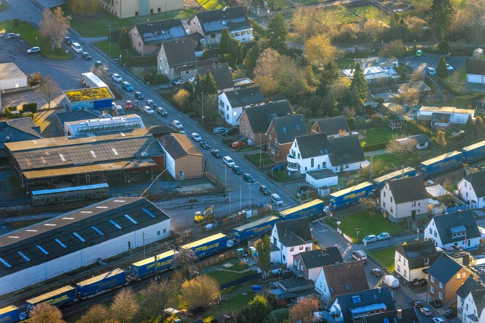 Aerial image Hamm - Driving a train with wagons from LKW Walter in freight traffic on the track at the level crossing Langewanneweg in Hamm in the Ruhr area in the state of North Rhine-Westphalia, Germany