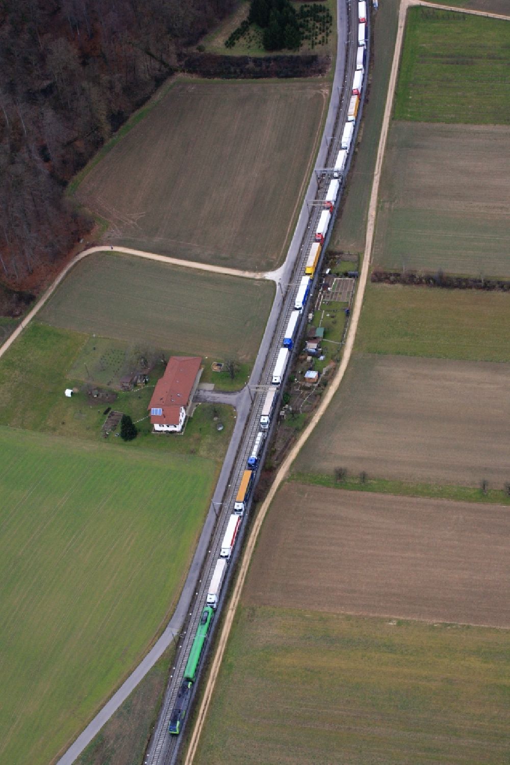 Aerial photograph Pratteln - Freight train with loaded trucks in Pratteln in Switzerland. The Alptransit NEAT is planning to expand the railways and to shift freight traffic for crossing the Alps from road to rail