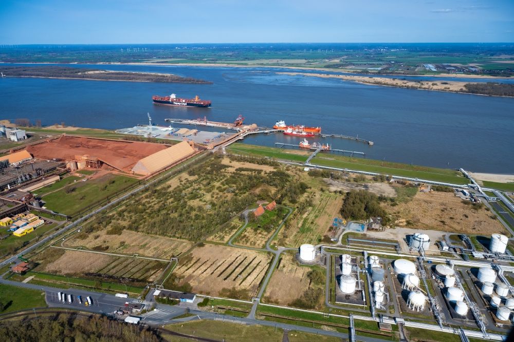 Stade from above - Port facility Stader Seehafen AOS am Buetzflether Sand in Buetzfleth in the state Lower Saxony, Germany. The Hanseatic Energy Hub is to be built on the green space by 2026. The planned terminal for the import of liquefied natural gas (LNG) will be integrated into the existing industrial park