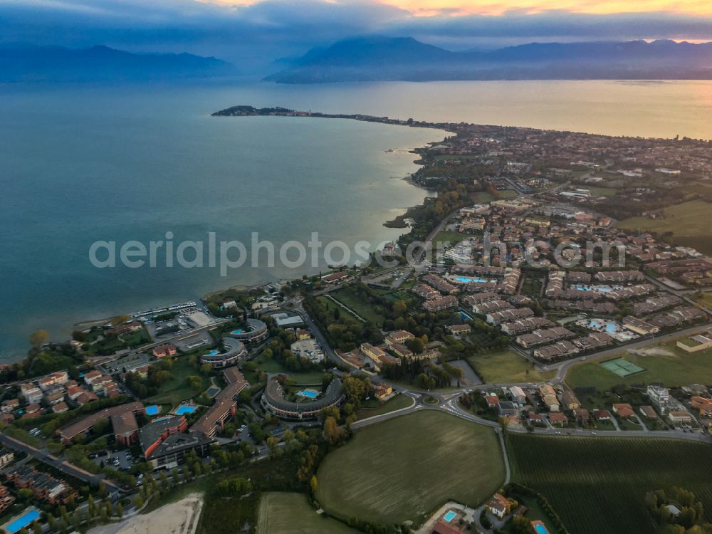 Aerial image Desenzano del Garda - Peninsula Sirmione with land access and shore area on the Gardasee in Morgenlicht in Desenzano del Garda in the Lombardy, Italy