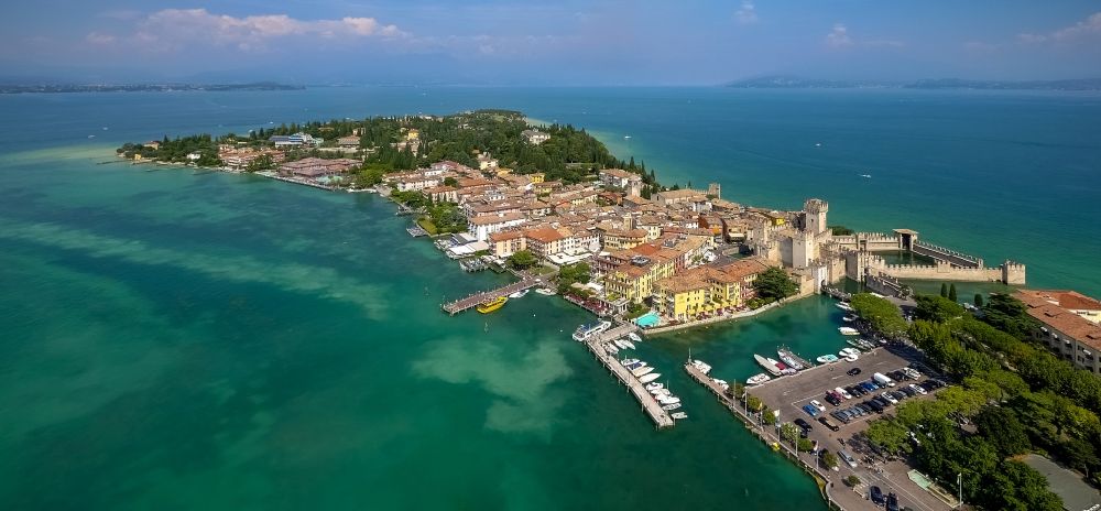 Aerial image Sirmione - Headland Sirmione at the Garda See in Lombardia, Italy. In the picture the castle Castello scaligero and the harbour