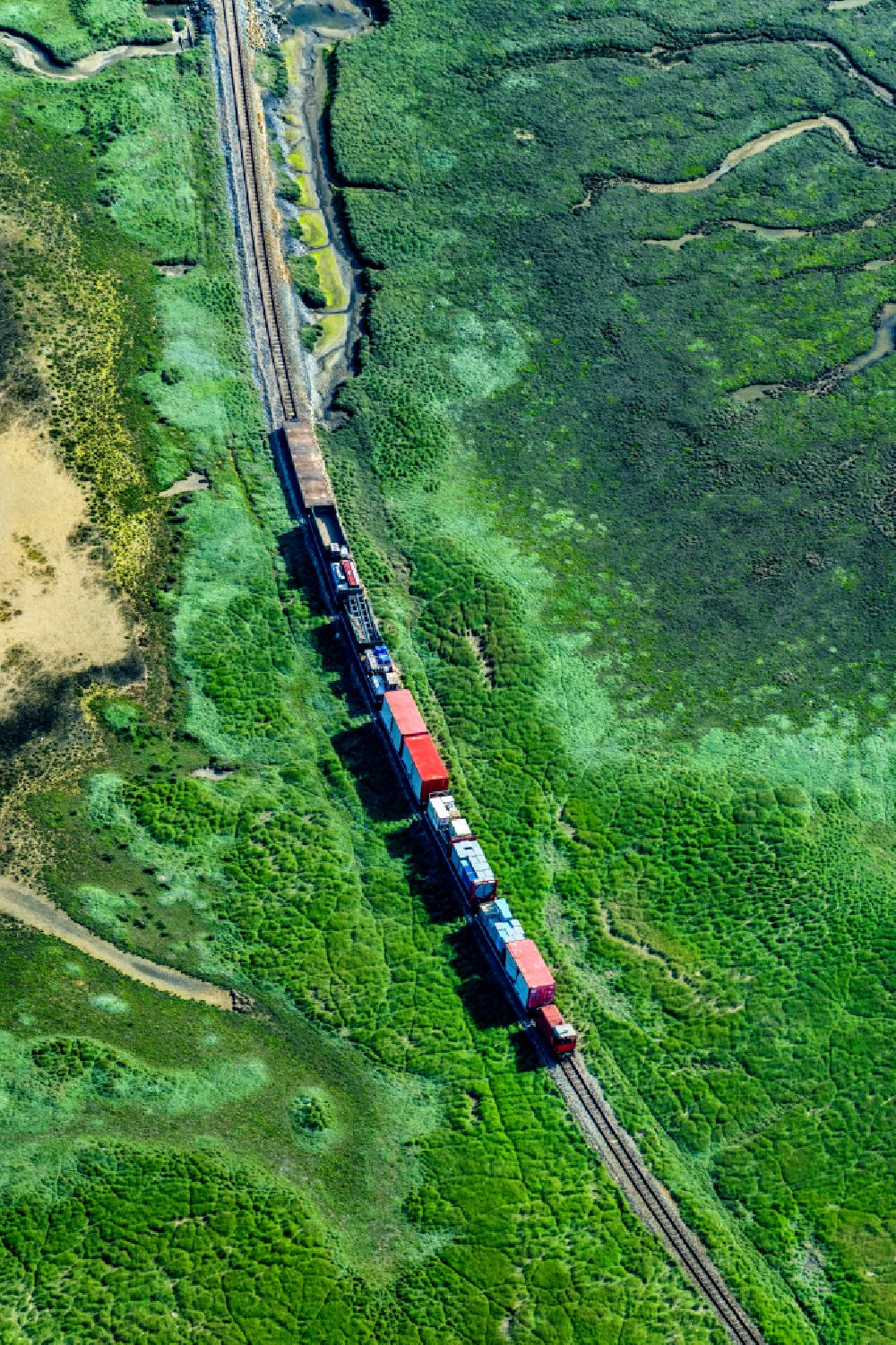 Wangerooge from above - Grassland structures of a Hallig landscape with moving train of the Wangerooger Inselbahn - narrow-gauge railway in Wangerooge in the state Lower Saxony, Germany