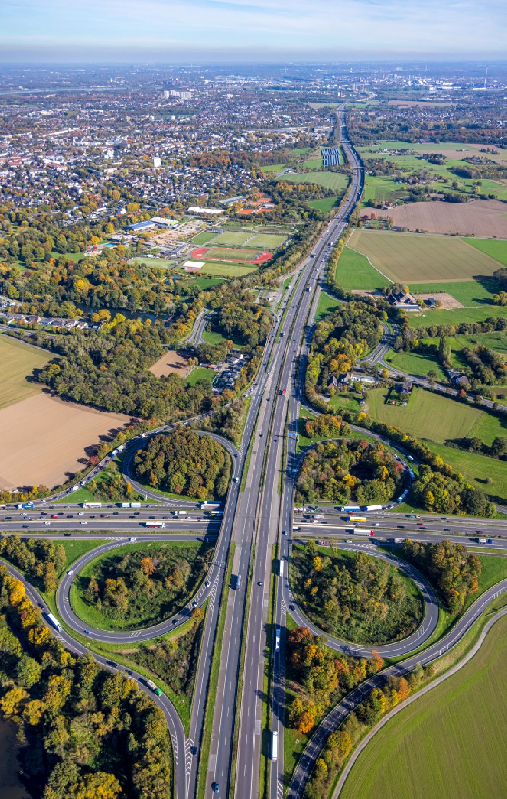 Aerial image Bettenkamp - Autumnal discolored vegetation view autumnal discolored view of vegetation Traffic routing and lanes in the road layout of the Autobahn junction of the BAB A40 and BAB A57 at Kreuz Moers - laid out in the shape of a cloverleaf in Bettenkamp in the state of North Rhine-Westphalia, Germany