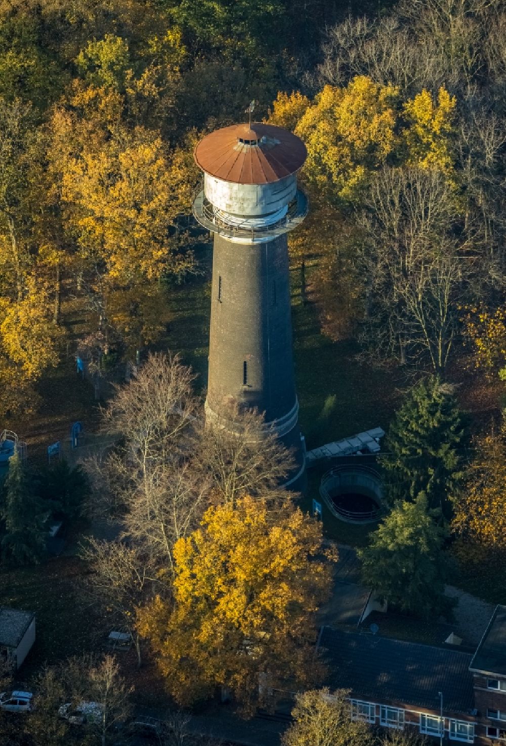 Moers from the bird's eye view: Autumnal discolored vegetation view building of industrial monument water tower of the Vinner Wasserturm on Vinner Strasse in Moers in the state North Rhine-Westphalia, Germany