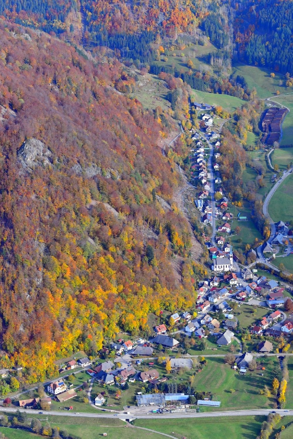 Todtnau from the bird's eye view: Autumnal discolored vegetation and location view of the of residential areas in the valley landscape surrounded by mountains in Geschwend in the state Baden-Wuerttemberg, Germany