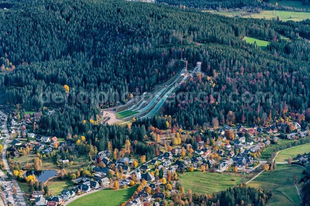 Hinterzarten from the bird's eye view: Autumnal discolored vegetation view location view of the streets and houses of residential areas in the valley landscape surrounded by mountains in Hinterzarten in the state Baden-Wuerttemberg, Germany