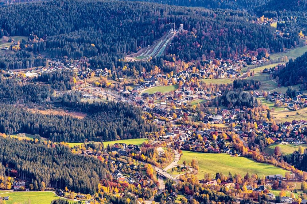 Hinterzarten from above - Autumnal discolored vegetation view location view of the streets and houses of residential areas in the valley landscape surrounded by mountains in Hinterzarten in the state Baden-Wuerttemberg, Germany