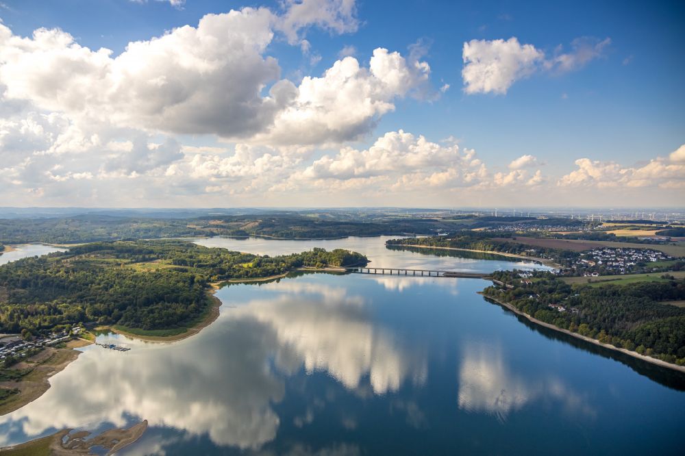 Möhnesee from the bird's eye view: Autumnal discolored vegetation view Dam and bank areas at the Moehnesee reservoir with cloud reflection in Moehnsee in the state North Rhine-Westphalia, Germany