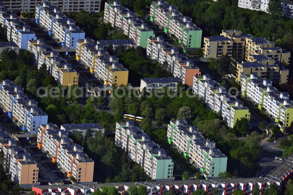Aerial photograph Berlin - Traversed by the Sonnenallee in the borough of Neukoelln in Berlin is the plate quarter-deck high settlement. The large estate with five-to six-storey buildings relies on a functional separation of pedestrians and car traffic and was at the time of construction as an innovative solution for urban development. High bearing, leafy paths the high-deck extending over the streets and parking spaces for cars. In recent years, solar panels were placed on the roofs