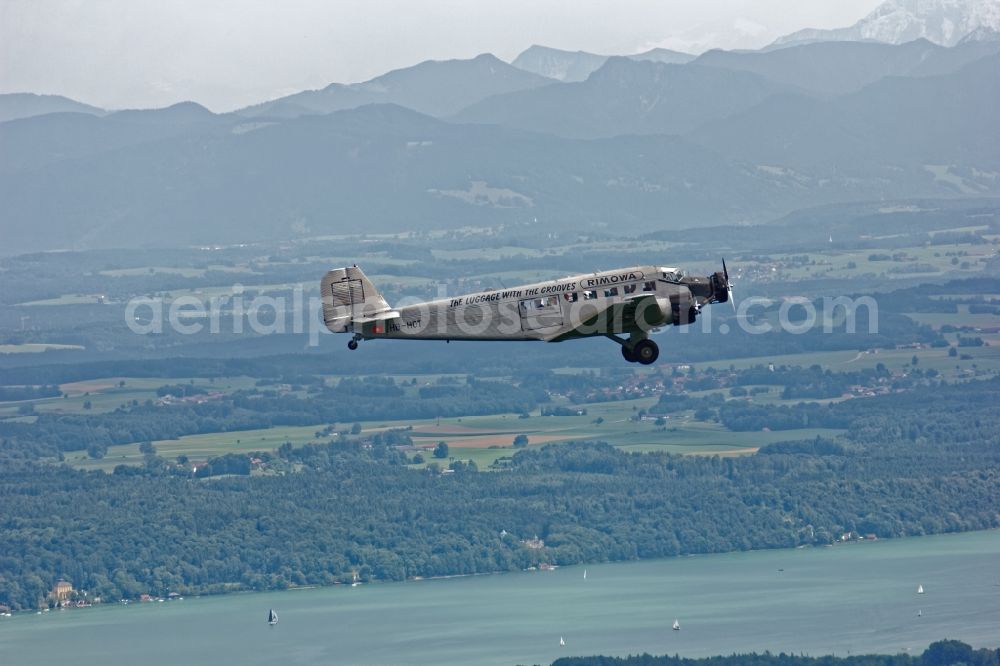 Starnberg from above - Historic aircraft Junkers Ju 52 on the fly over the airspace near Starnberg in the state Bavaria, Germany