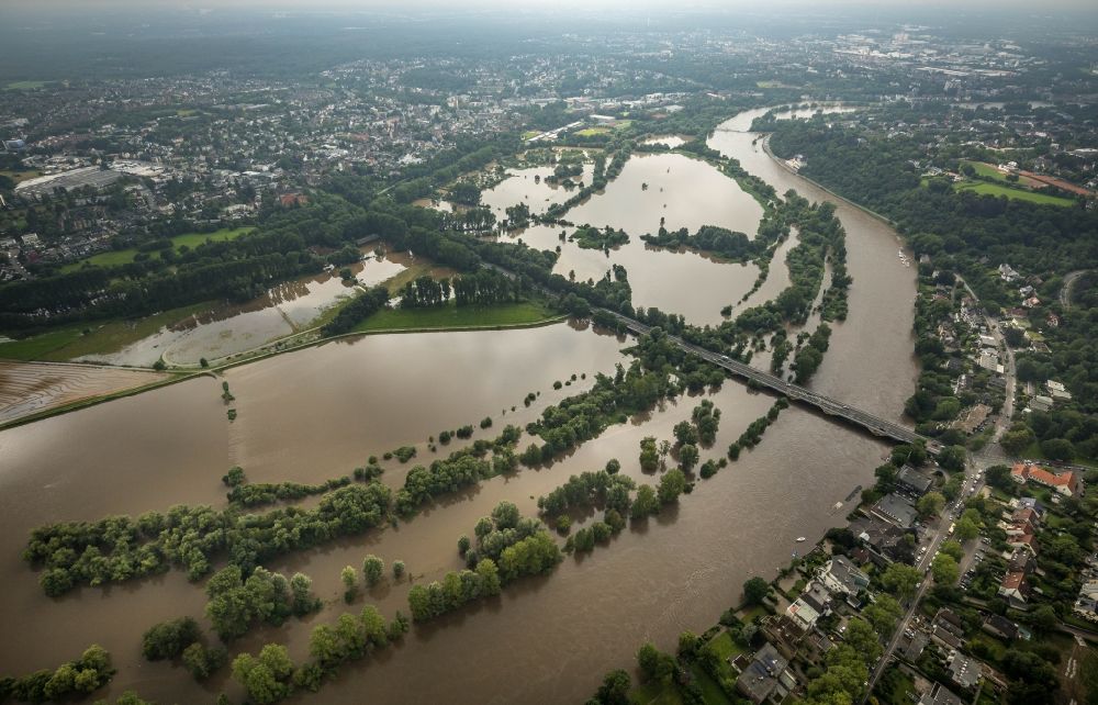 Mülheim an der Ruhr from the bird's eye view: Flood situation and flooding, all-rousing and infrastructure-destroying masses of brown water on the course of the Ruhr in Muelheim on the Ruhr at Ruhrgebiet in the state North Rhine-Westphalia, Germany