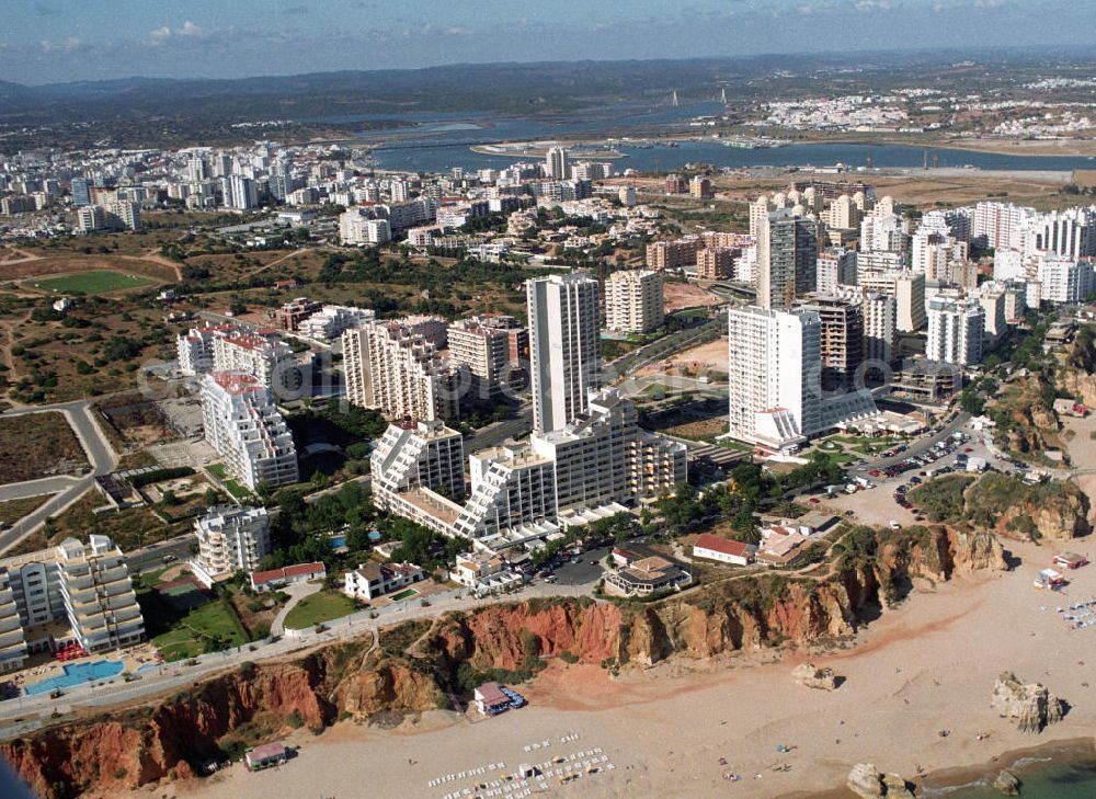 Aerial image Praia da Rocha - Blick auf ein Hotelkomplex in Praia da Rocha an der Algarve in Portugal. Praia da Rocha ist ein beliebter Strand und entstanden ist der ca. 1,5 km lange Küstenabschnitt durch die Meeresauswaschung von härteren Felsgestein aus dem sie umgebendem weicheren Material an der hier ca. 20-30 m hohen Steilküste. Oberhalb der Steilkante haben sich zahlreiche Hotels, Ferienwohnungen, Restaurants und Geschäfte den Standortvorteil gesichert.