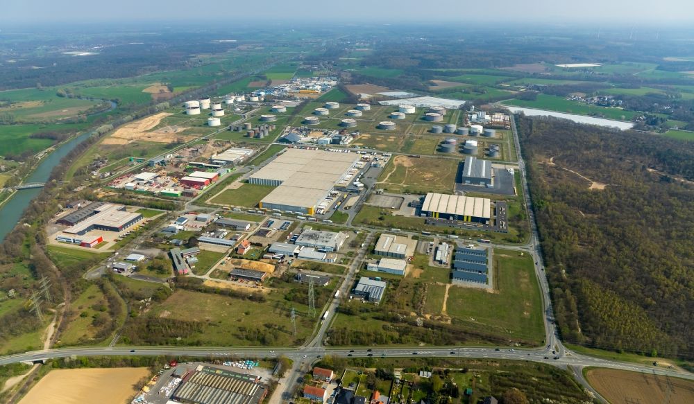 Aerial photograph Hünxe - Industrial and commercial area between Weseler Strasse and Hans-Richter-Strasse overlooking mineral oil - high tank storages of the Soepenberg GmbH and the warehouses and freight forwarding buildings of the LGI Logistics Group International GmbH in the district Bucholtwelmen in Huenxe in the state North Rhine-Westphalia, Germany