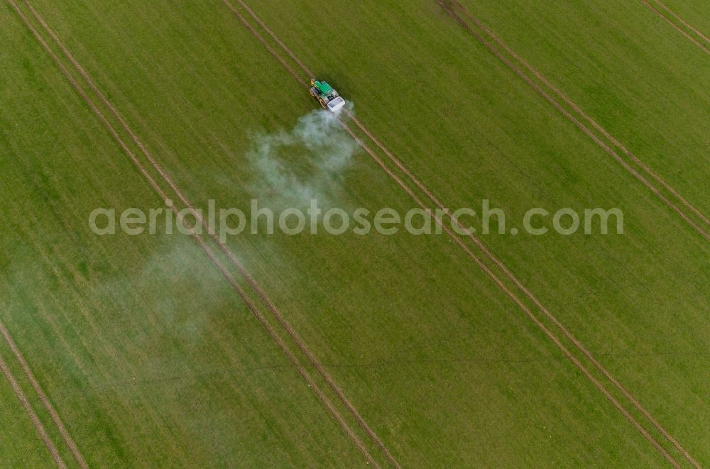 Aerial photograph Gammelin - Spraying of lime as fertilizer with tractor and special attachment on agricultural fields in Gammelin in the state Mecklenburg - Western Pomerania, Germany