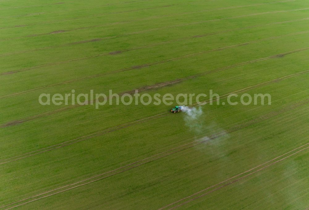 Aerial image Gammelin - Spraying of lime as fertilizer with tractor and special attachment on agricultural fields in Gammelin in the state Mecklenburg - Western Pomerania, Germany