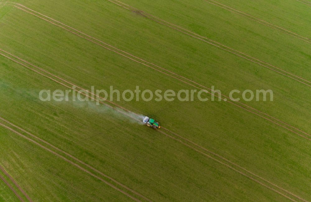 Aerial photograph Gammelin - Spraying of lime as fertilizer with tractor and special attachment on agricultural fields in Gammelin in the state Mecklenburg - Western Pomerania, Germany
