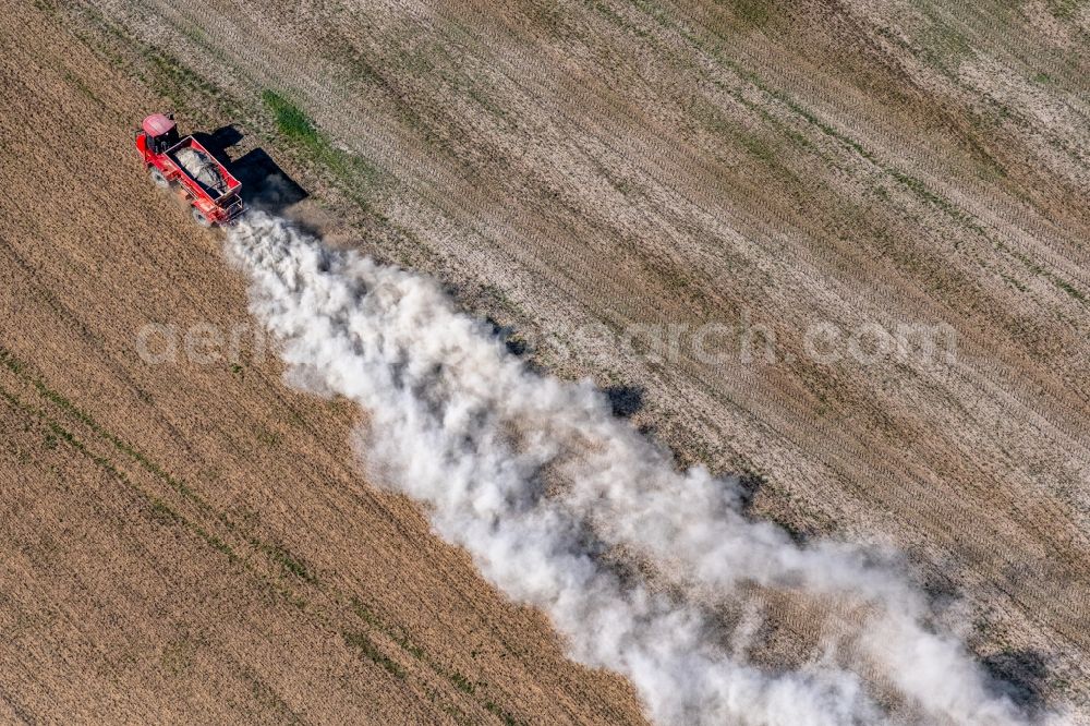 Trebnitz from the bird's eye view: Spraying of lime as fertilizer with tractor and special attachment on agricultural fields in Trebnitz in the state Saxony-Anhalt, Germany