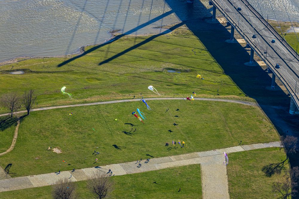 Düsseldorf from the bird's eye view: Playing children fly kites on the structures of a field landscape Rheinwiesen on the banks of the rhine river course at Rheinkniebruecke in Duesseldorf in the state North Rhine-Westphalia, Germany