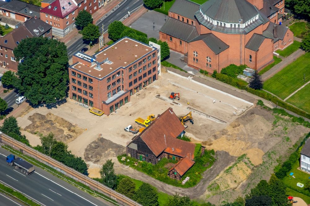 Aerial photograph Gladbeck - Church building of the Catholic Parish of the Holy Cross in Gladbeck in North Rhine-Westphalia. The focus of the new building of the family doctor center Butendorf at the Horster street