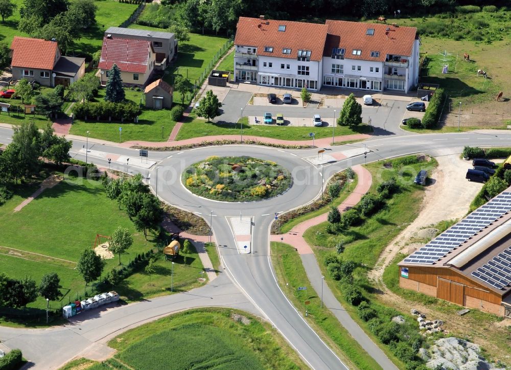 Aerial image Holzhausen - At the eastern entrance of Holzhausen in the state of Thuringia is a roundabout. On the traffic island in the middle of the roundabout there is a sculpture of a sausage made ??of wood. In Holzhausen is the German Bratwurst Museum