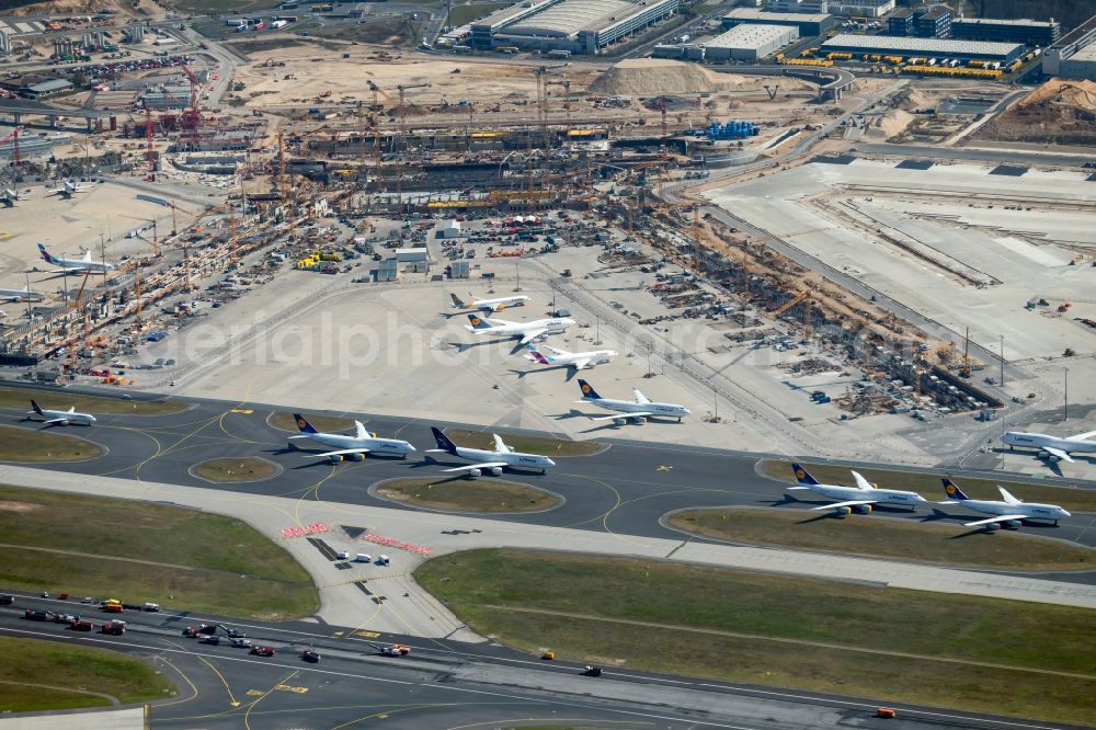 Kelsterbach from above - Due to the crisis, passenger aircraft of the airline Lufthansa parked on the runway west in parking position on parking spaces at the airport Frankfurt Airport in Kelsterbach in the state Hesse, Germany