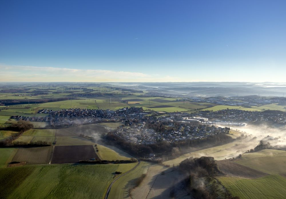 Ense from above - Landscape around the municipality Emse in the morning mist in the state of North Rhine-Westphalia. In the backfround a wind powerplant with several wind turines can be seen