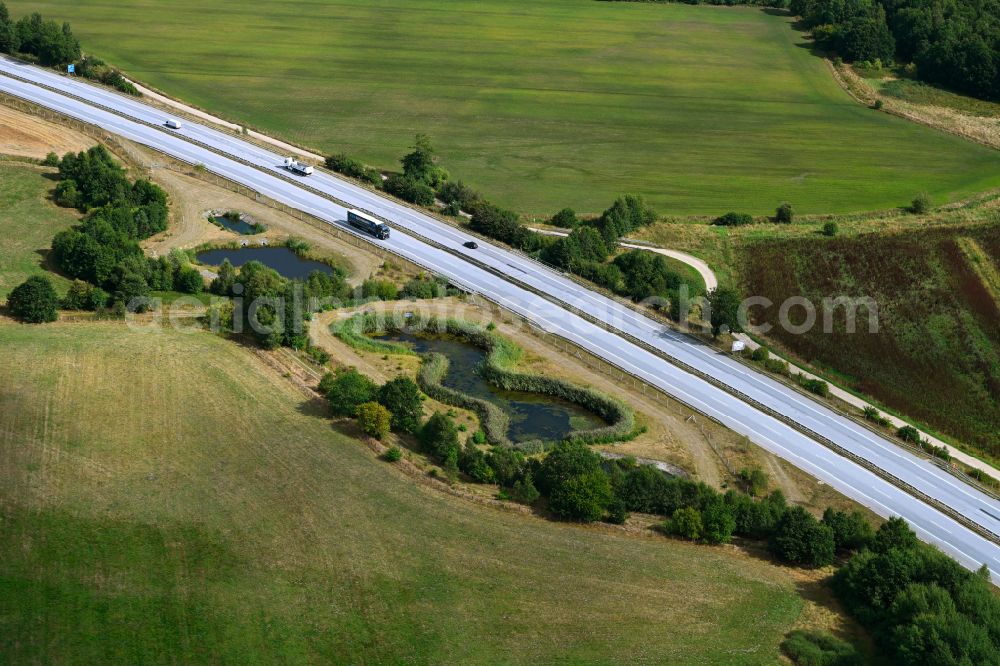 Negernbötel from the bird's eye view: Agricultural fields surround the lanes of the motorway route and the route of the BAB A 21 with angrenzenden Wasserauffangbecken in Negernboetel in the state Schleswig-Holstein, Germany