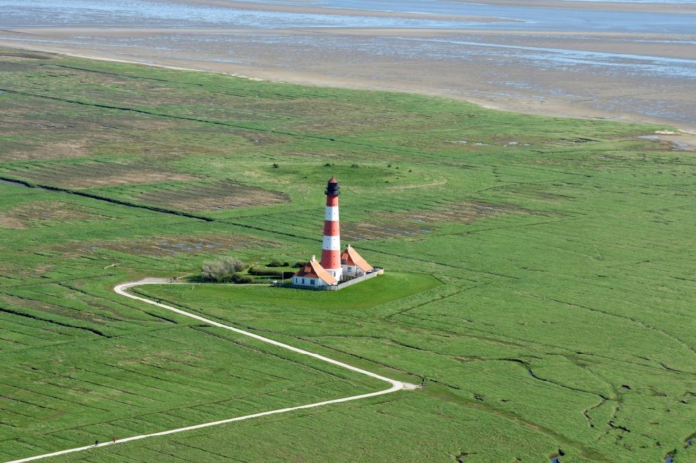 Tating from above - Westerheversand lighthouse as a historic seafaring character in the coastal area of the North Sea in Tating in the state of Schleswig-Holstein