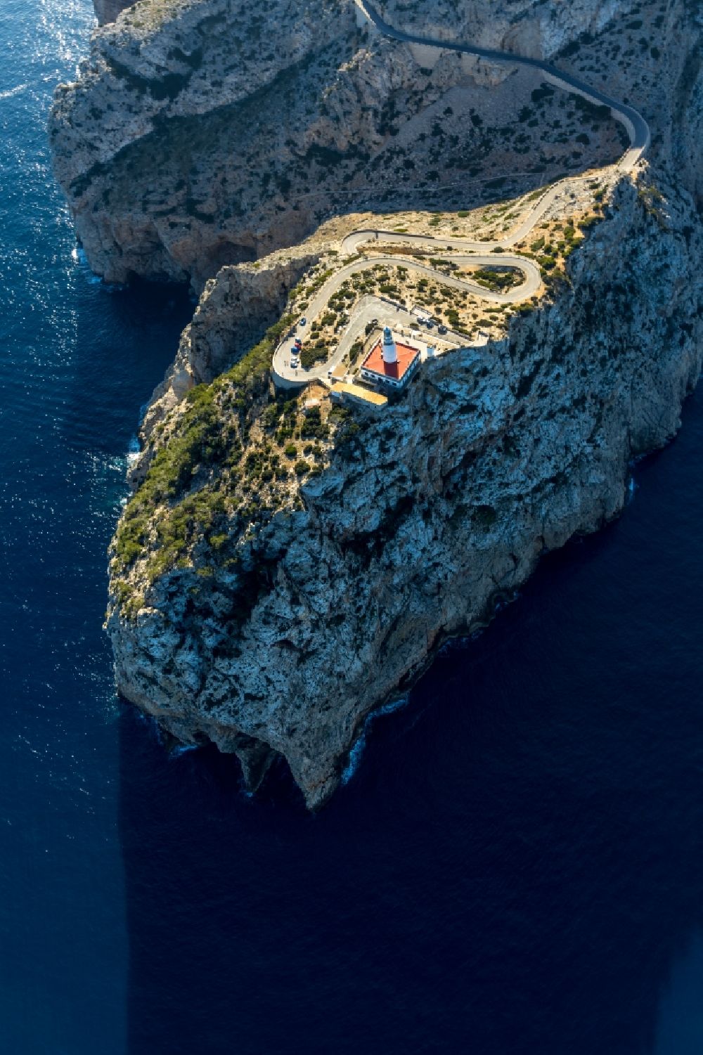 Aerial image Pollenca - Lighthouse as a historic seafaring character in the coastal area in Pollenca in Balearische Insel Mallorca, Spain